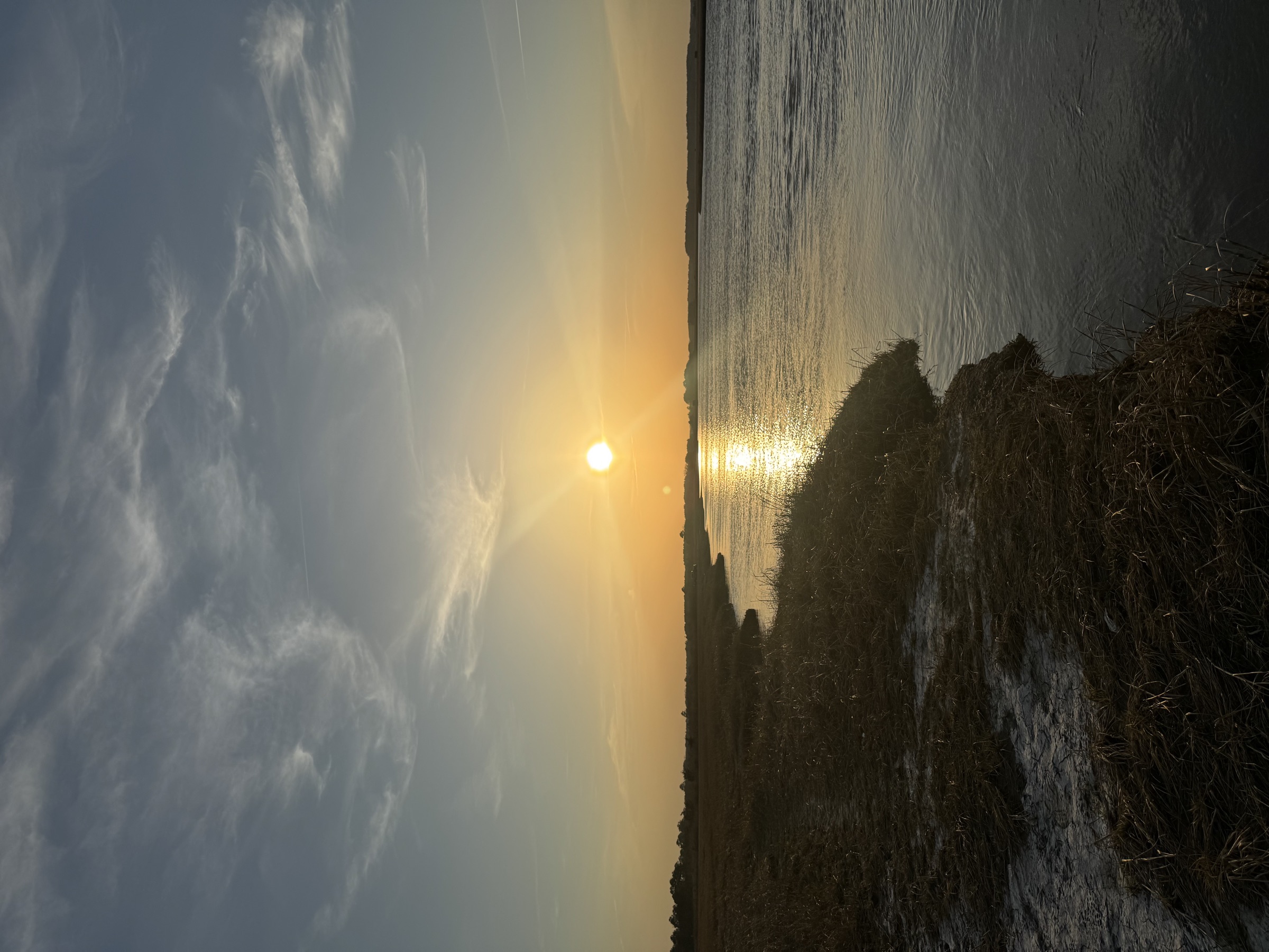 Tidal channel through coastal marsh at sunset