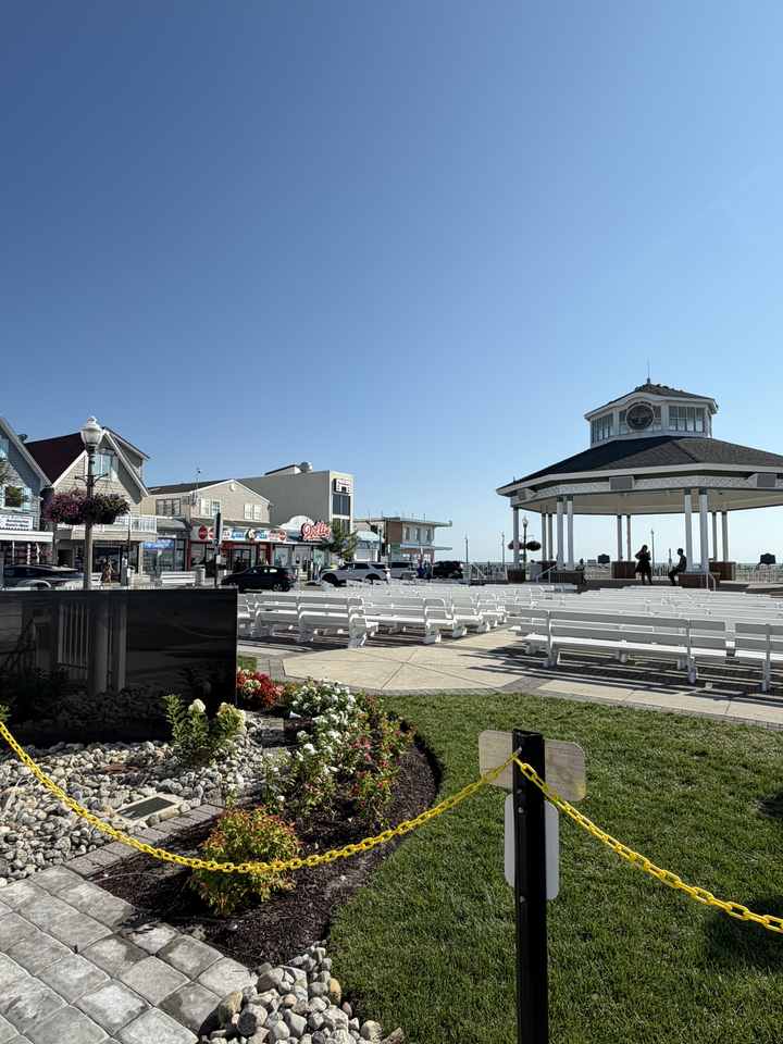 The Rehoboth Beach Bandstand and the boardwalk entrance under a clear sky